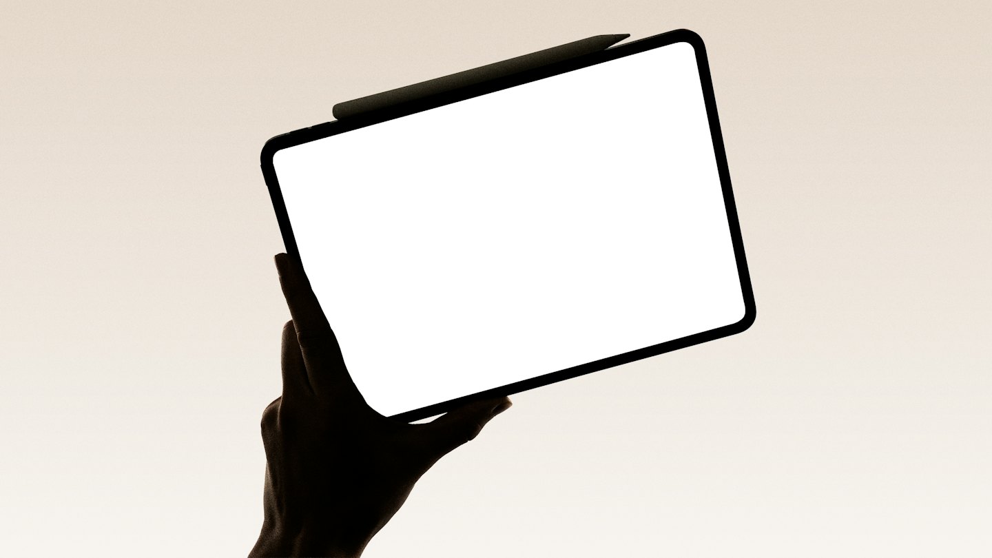 Hand holding a tablet with an attached digital pen.